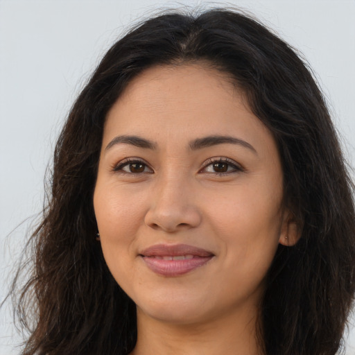 Joyful latino young-adult female with long  brown hair and brown eyes