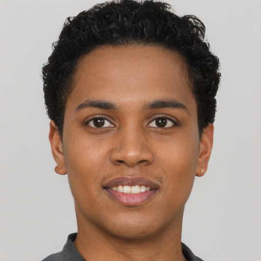 Joyful black young-adult male with short  black hair and brown eyes