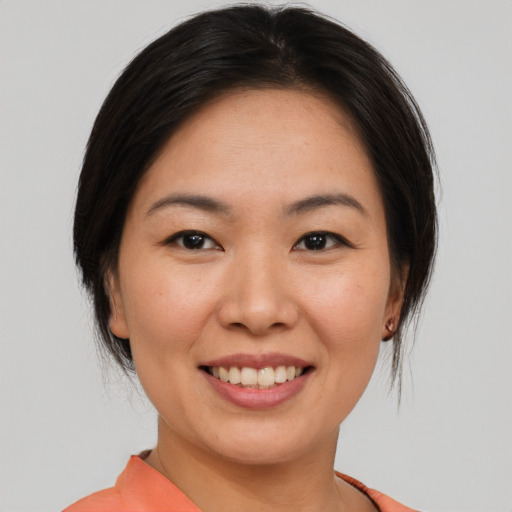 Joyful asian young-adult female with medium  brown hair and brown eyes