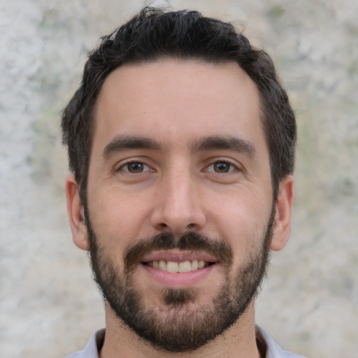 Joyful white young-adult male with short  black hair and brown eyes