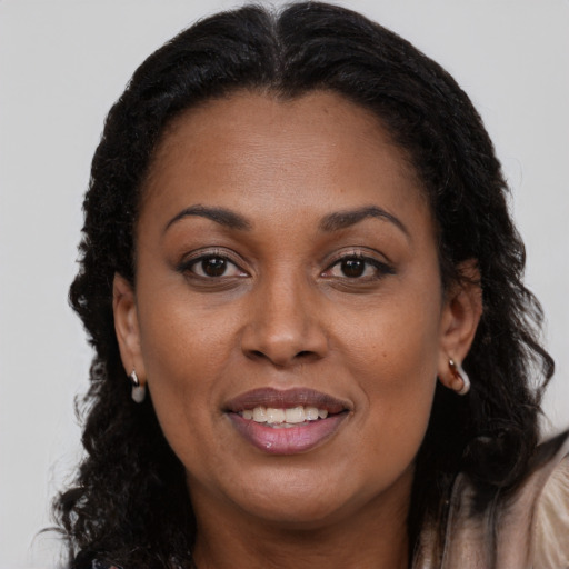 Joyful black adult female with long  brown hair and brown eyes