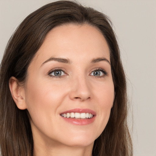 Joyful white young-adult female with long  brown hair and brown eyes