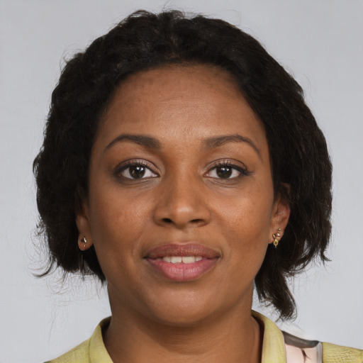 Joyful black adult female with medium  brown hair and brown eyes