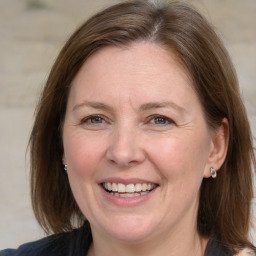 Joyful white adult female with medium  brown hair and blue eyes