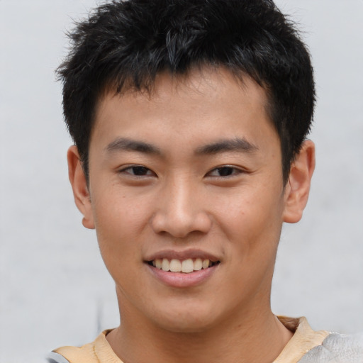 Joyful asian young-adult male with short  brown hair and brown eyes
