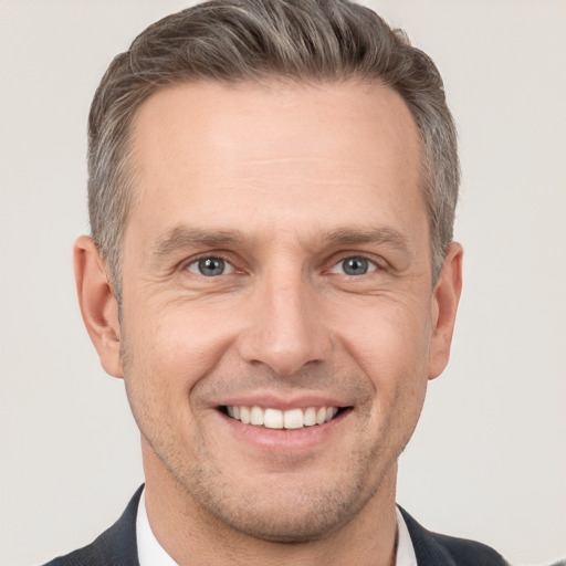 Joyful white adult male with short  brown hair and brown eyes