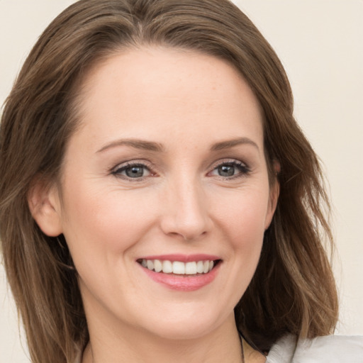 Joyful white young-adult female with medium  brown hair and grey eyes