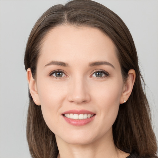 Joyful white young-adult female with long  brown hair and brown eyes