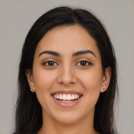 Joyful latino young-adult female with long  brown hair and brown eyes