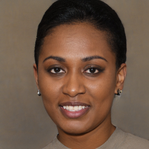 Joyful black young-adult female with short  black hair and brown eyes