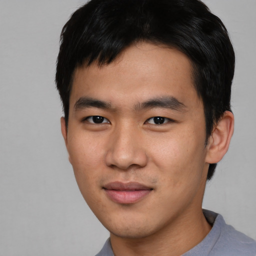 Joyful asian young-adult male with short  black hair and brown eyes
