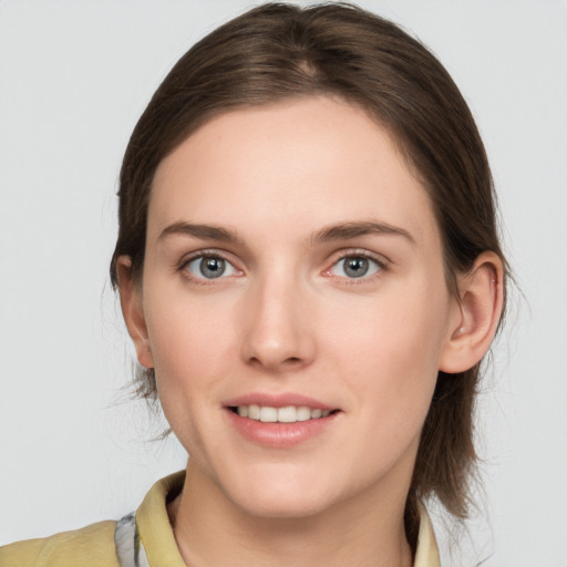 Joyful white young-adult female with medium  brown hair and grey eyes