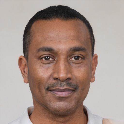 Joyful black adult male with short  black hair and brown eyes