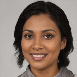 Joyful black young-adult female with medium  brown hair and brown eyes