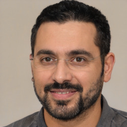 Joyful white adult male with short  black hair and brown eyes