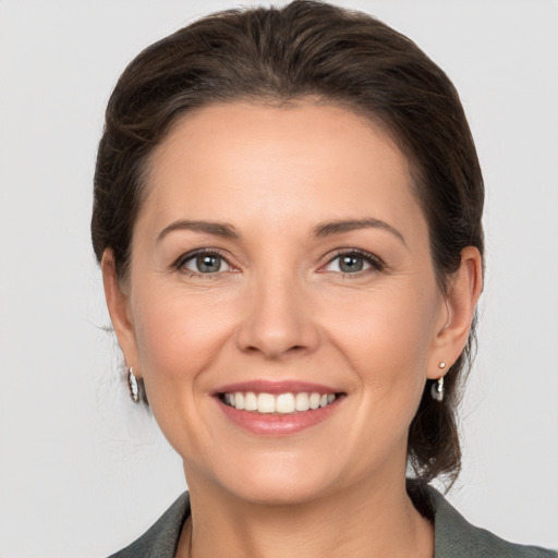 Joyful white young-adult female with medium  brown hair and grey eyes