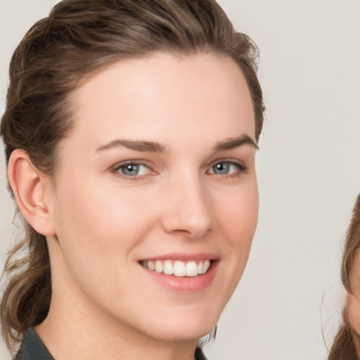 Joyful white young-adult female with long  brown hair and grey eyes