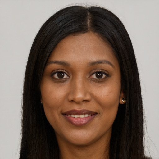 Joyful black young-adult female with long  brown hair and brown eyes
