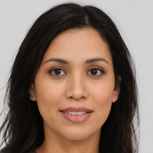 Joyful latino young-adult female with long  brown hair and brown eyes