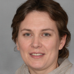 Joyful white adult female with medium  brown hair and grey eyes