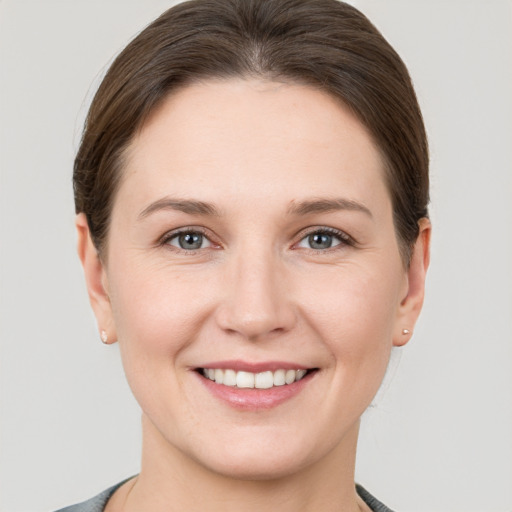 Joyful white young-adult female with short  brown hair and grey eyes