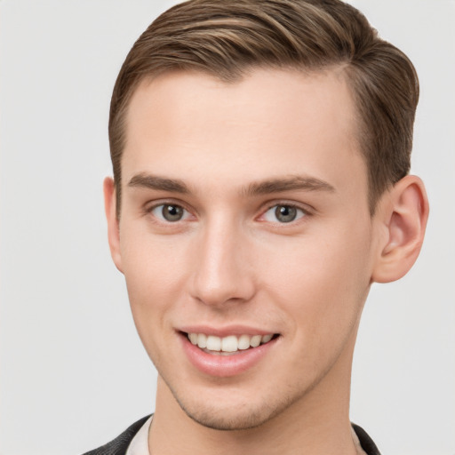 Joyful white young-adult male with short  brown hair and grey eyes