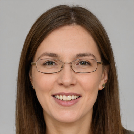 Joyful white young-adult female with long  brown hair and blue eyes