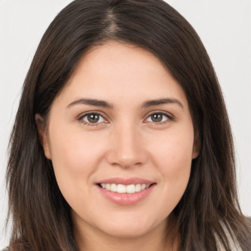 Joyful white young-adult female with long  brown hair and brown eyes