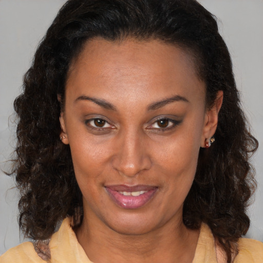 Joyful black adult female with medium  brown hair and brown eyes