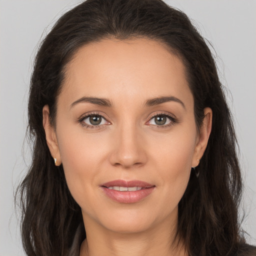 Joyful white young-adult female with long  brown hair and brown eyes