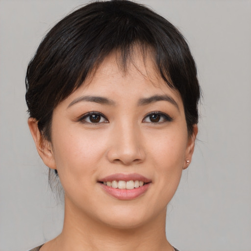 Joyful asian young-adult female with short  brown hair and brown eyes