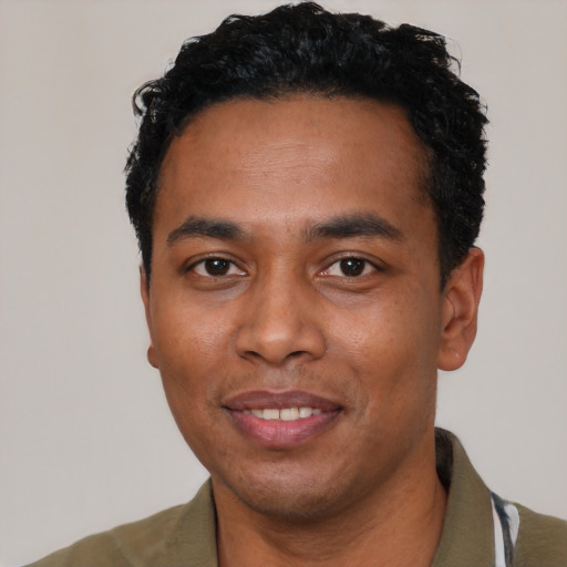 Joyful black young-adult male with short  black hair and brown eyes