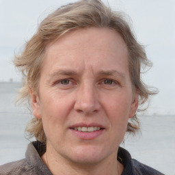 Joyful white adult female with medium  brown hair and blue eyes