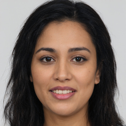 Joyful latino young-adult female with long  brown hair and brown eyes