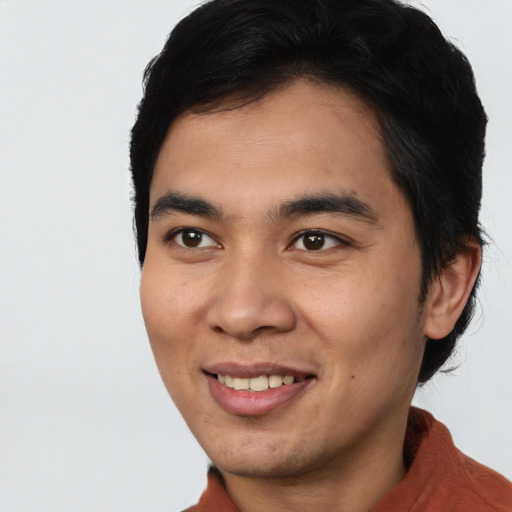 Joyful asian young-adult male with short  black hair and brown eyes