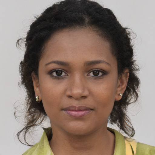 Joyful black young-adult female with medium  brown hair and brown eyes