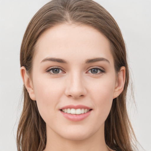 Joyful white young-adult female with long  brown hair and grey eyes