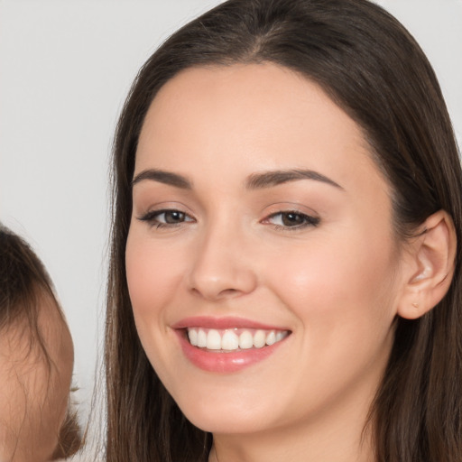 Joyful white young-adult female with long  brown hair and brown eyes