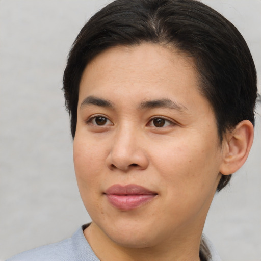Joyful asian young-adult female with short  brown hair and brown eyes