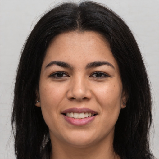 Joyful latino young-adult female with long  brown hair and brown eyes