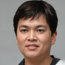 Joyful asian young-adult male with short  black hair and brown eyes