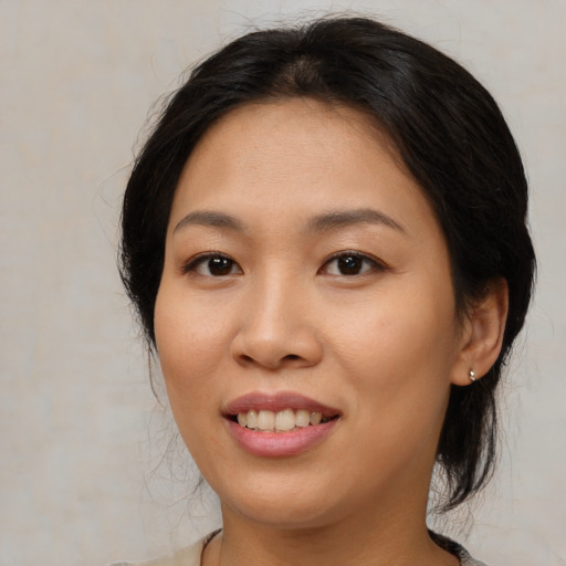Joyful asian young-adult female with medium  brown hair and brown eyes