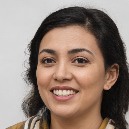 Joyful latino young-adult female with medium  brown hair and brown eyes
