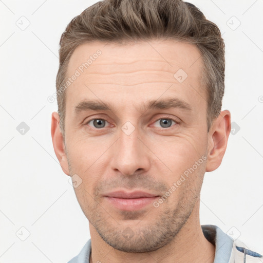 Joyful white young-adult male with short  brown hair and grey eyes