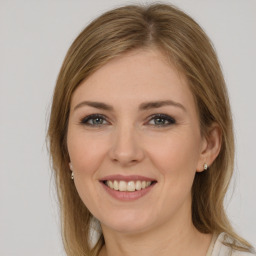 Joyful white young-adult female with long  brown hair and green eyes