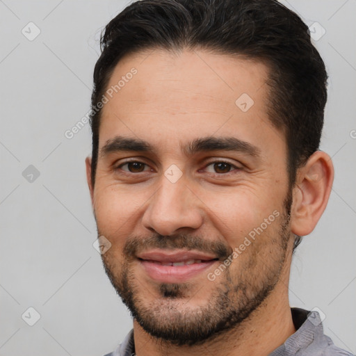 Joyful white young-adult male with short  black hair and brown eyes