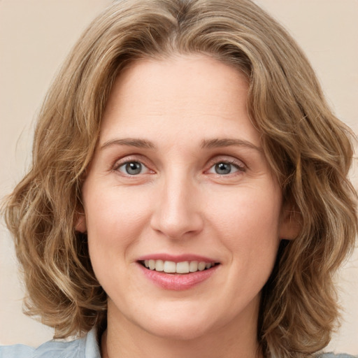 Joyful white young-adult female with medium  brown hair and green eyes