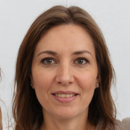 Joyful white adult female with long  brown hair and brown eyes