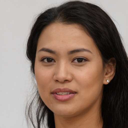 Joyful asian young-adult female with long  brown hair and brown eyes