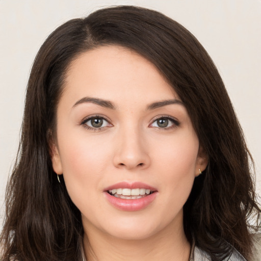 Joyful white young-adult female with long  brown hair and brown eyes